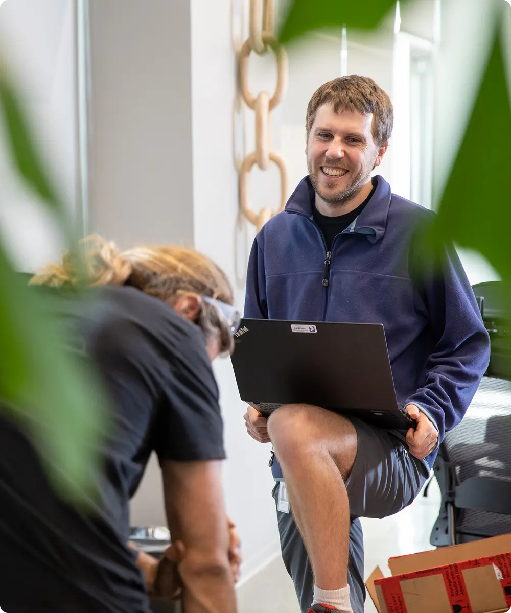 Man holding laptop smiling